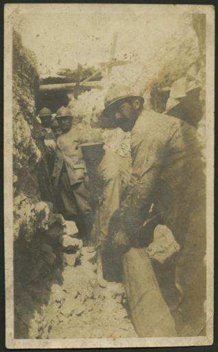 Photographies de camarades d'Athanase Carteau : Dr Furet, médecin auxiliaire, en train de déblayer une tranchée (vue 1) ; groupe de brancardiers photographié par le Dr Furet à la ferme de Lassigny (Hébuterne, Pas-de-Calais), 1er semestre 1915 (vue 2). - 2 photographies.